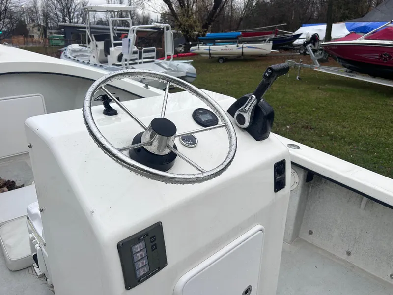 Slide: The Image of Flying Point Boatworks FP 21, 2020 model, steering console with throttle, parked outdoors. - 7