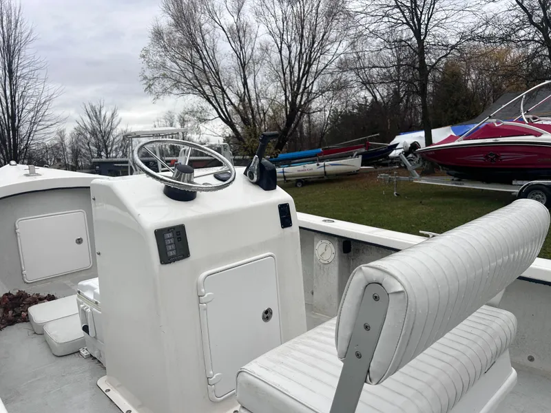 Slide: The Image of 2020 Flying Point Boatworks FP 21 with white interior, parked outdoors near other boats. - 8