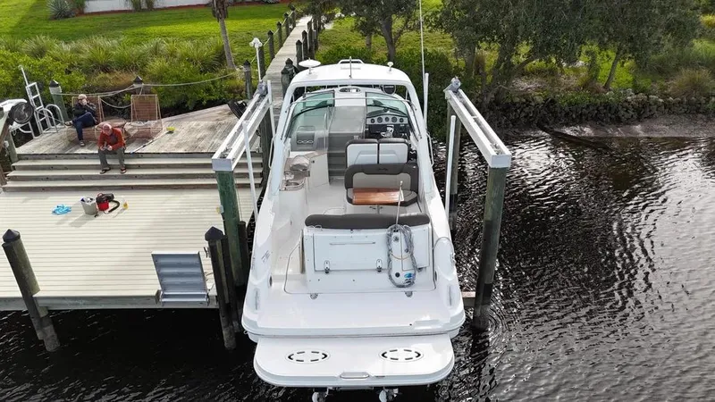 Slide: The Image of 2015 Sea Ray 330 Sundancer docked at a waterfront pier. - 1