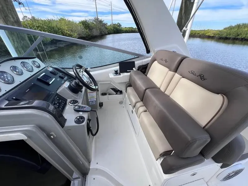 Slide: The Image of 2015 Sea Ray 330 Sundancer cockpit with plush seating and modern controls. - 10