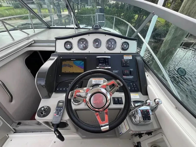 Slide: The Image of 2015 Sea Ray 330 Sundancer helm with modern navigation controls and steering wheel. - 12