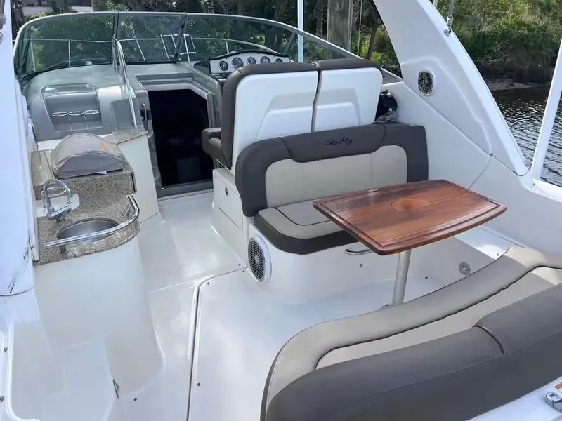 Slide: The Image of 2015 Sea Ray 330 Sundancer interior with seating, table, and kitchenette. - 6