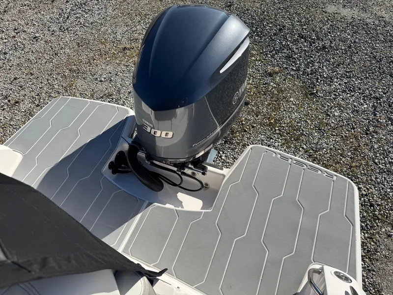 Slide: The Image of 2019 Regal 26 XO boat with 300 HP outboard engine on gravel surface. - 10