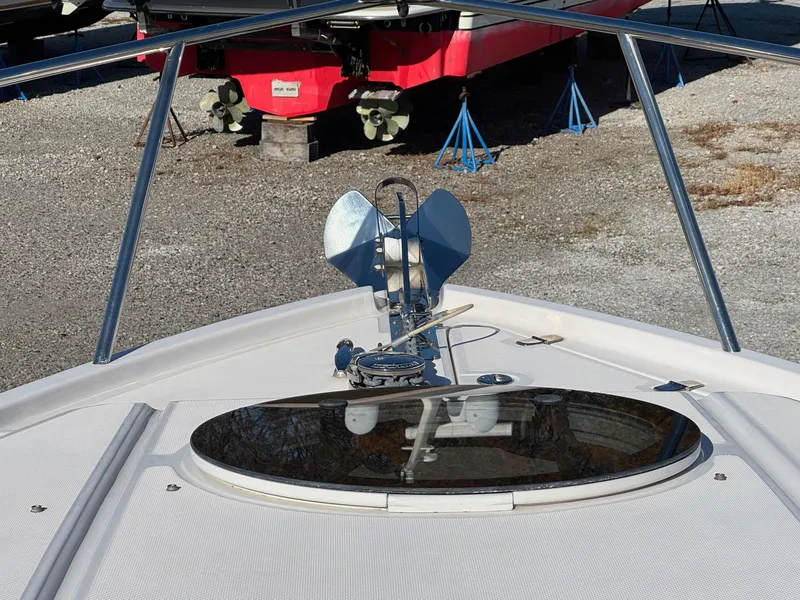 Slide: The Image of 2019 Regal 26 XO boat bow with anchor and hatch on gravel surface. - 13