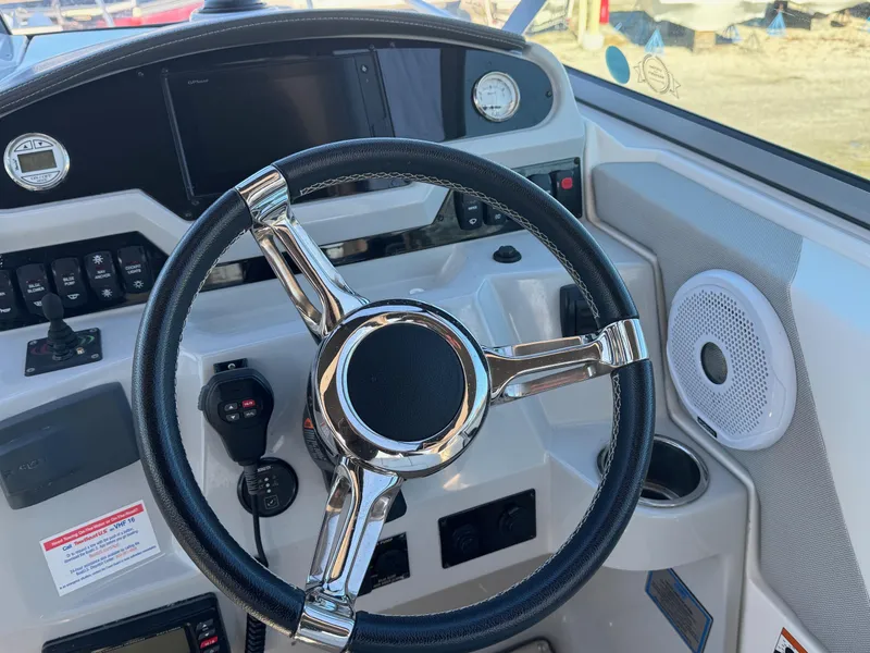 Slide: The Image of 2019 Regal 26 XO boat dashboard with steering wheel and controls. - 15