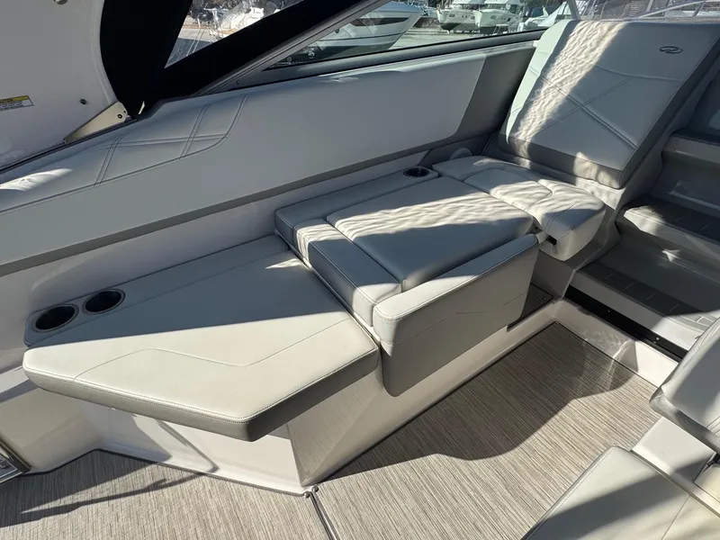 Slide: The Image of 2019 Regal 26 XO boat interior with cushioned seating and cup holders. - 22
