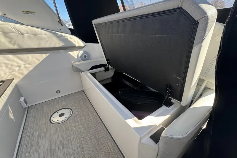 Slide: The Image of 2019 Regal 26 XO boat interior with open storage compartment and cushioned seating. - 23