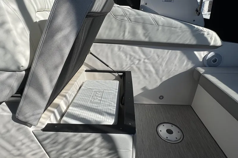 Slide: The Image of 2019 Regal 26 XO boat interior with open storage compartment and cushioned seating. - 24