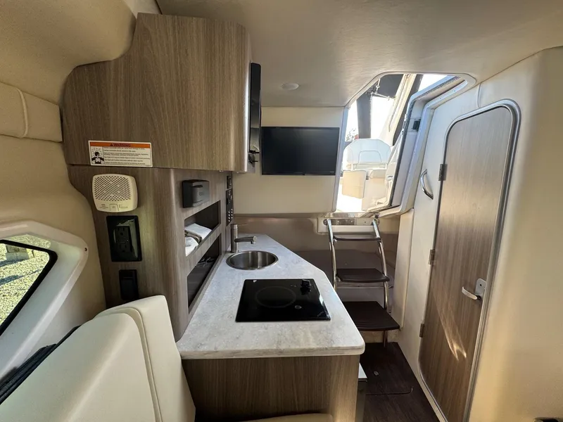 Slide: The Image of 2019 Regal 26 XO boat interior with kitchenette and seating area. - 27