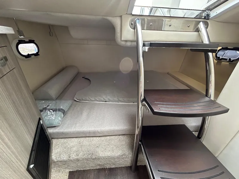 Slide: The Image of 2019 Regal 26 XO cabin interior with bed and wooden steps. - 31
