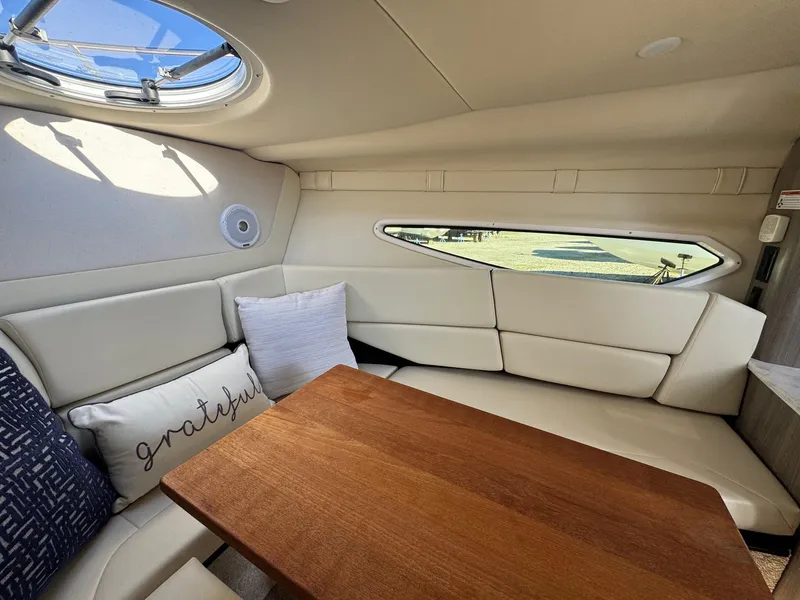 Slide: The Image of 2019 Regal 26 XO boat interior with cozy seating and wooden table. - 32