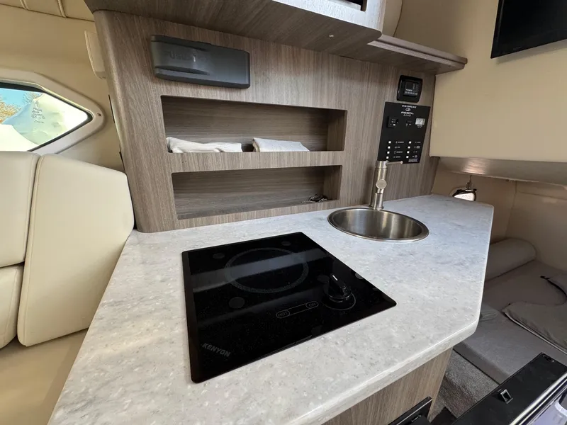 Slide: The Image of 2019 Regal 26 XO boat interior with kitchenette, sink, and stove. - 40