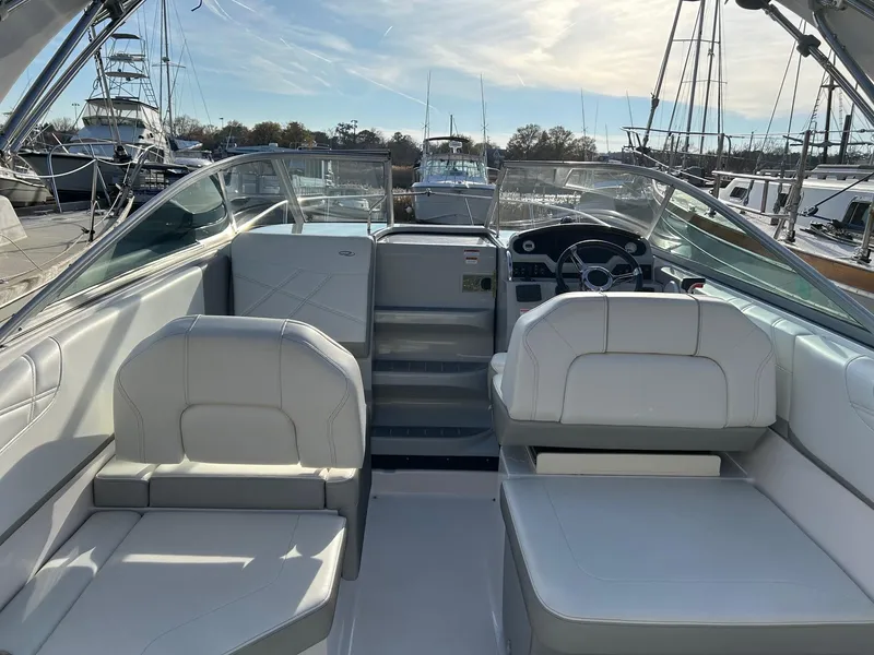 Slide: The Image of 2019 Regal 26 XO boat interior with white seating and steering wheel, docked at marina. - 5