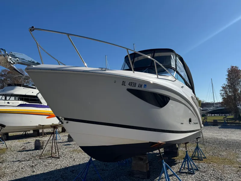 Slide: The Image of 2019 Regal 26 XO boat on stands in a gravel lot under clear blue sky. - 7