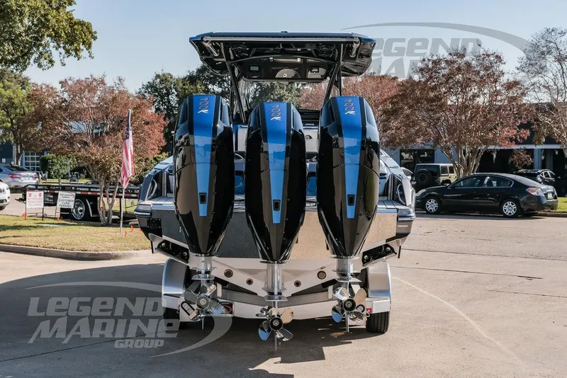 Slide: The Image of 2025 Nor-Tech 340 Sport boat with triple engines, parked outdoors. - 6