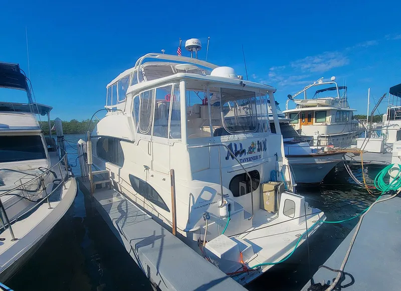 Slide: The Image of 2005 Silverton 43 Motor Yacht docked at marina under clear blue sky. - 0