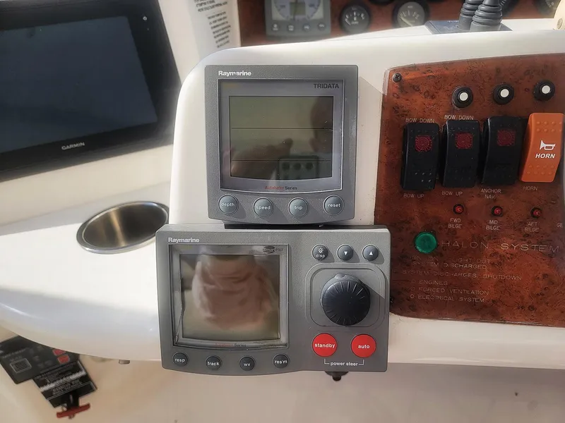 Slide: The Image of Control panel of a 2005 Silverton 43 Motor Yacht with navigation displays and switches. - 14