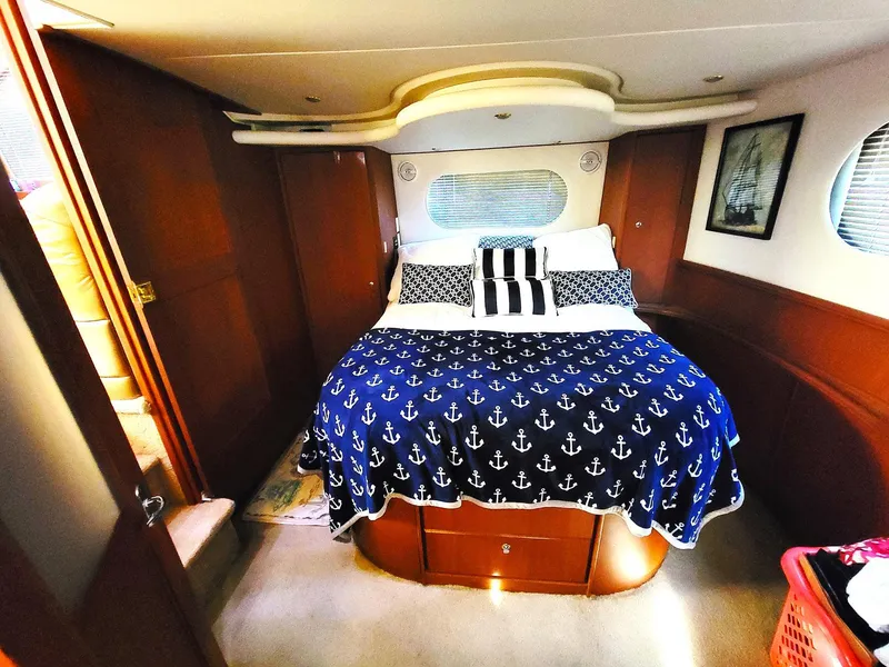 Slide: The Image of Luxurious 2005 Silverton 43 Motor Yacht bedroom with nautical-themed bedding. - 7