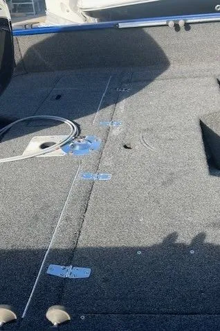 Slide: The Image of 2014 Lowe Fishing Machine FM165WT boat interior with carpeted deck and storage compartments. - 4