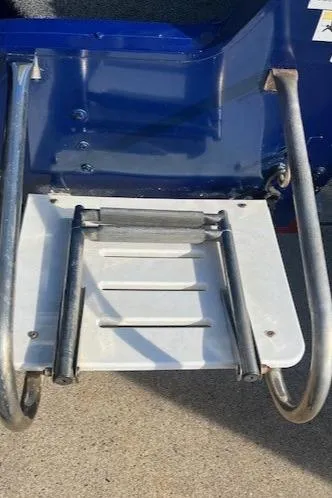 Slide: The Image of 2014 Lowe Fishing Machine FM165WT boat ladder, metal and white, attached to blue hull. - 5