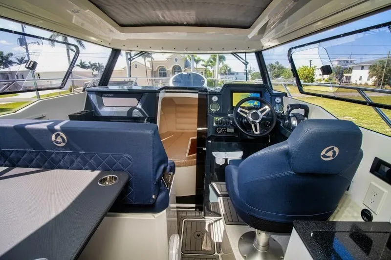 Slide: The Image of 2024 Skamander 920 Explorer Max boat interior with modern dashboard and blue seating. - 23