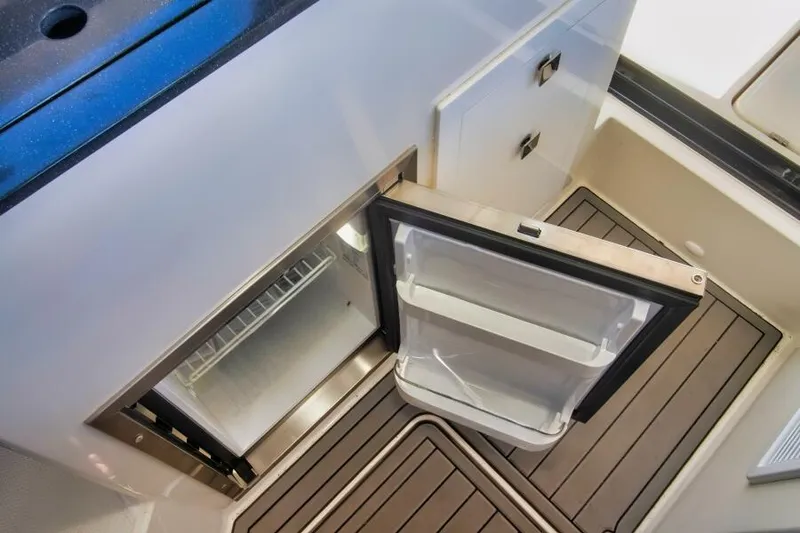 Slide: The Image of 2024 Skamander 920 Explorer Max interior with open fridge and modern cabinetry. - 24