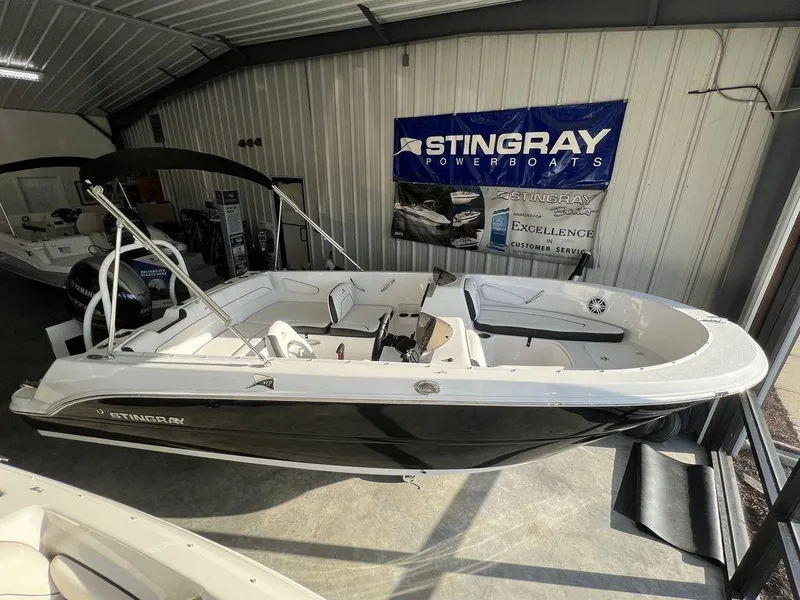Slide: The Image of 2025 Stingray 172SC boat displayed in showroom, featuring sleek black and white design. - 5