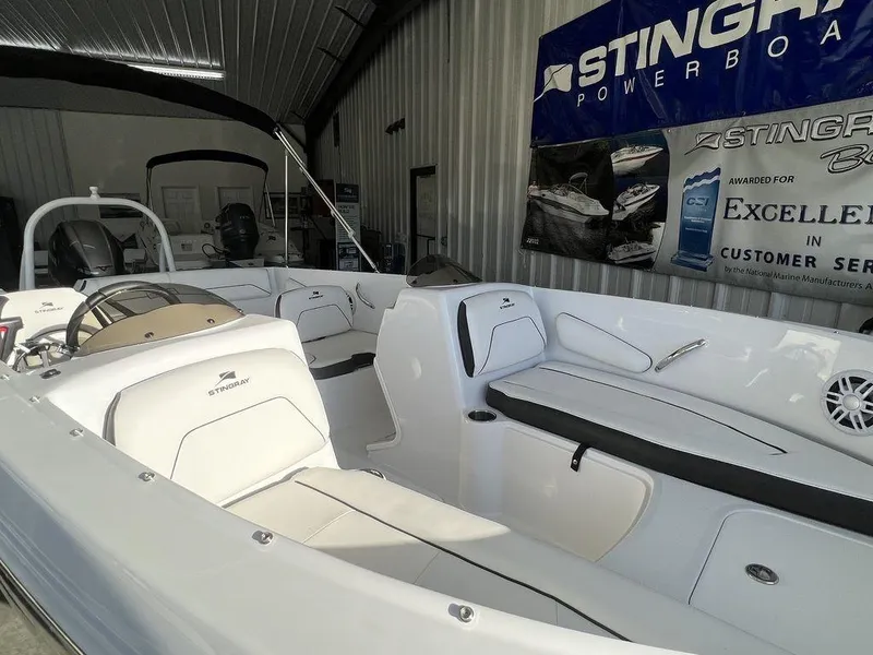 Slide: The Image of 2025 Stingray 172SC boat interior in showroom, featuring white seating and modern design. - 6
