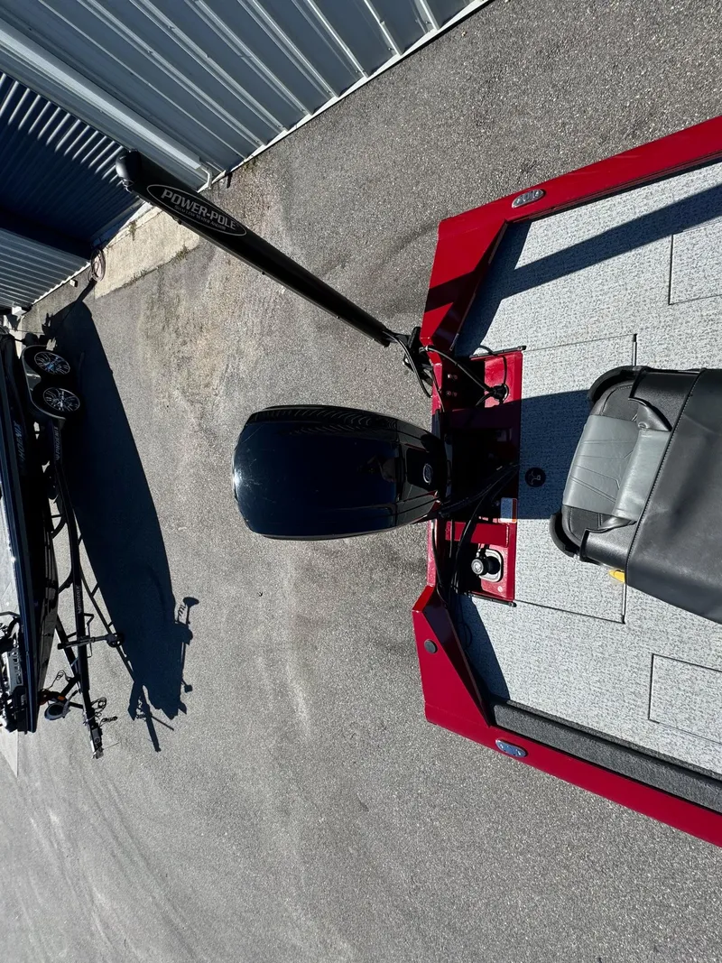 Slide: The Image of 2020 Bass Tracker 175 TF boat, red and gray, parked on pavement. - 12