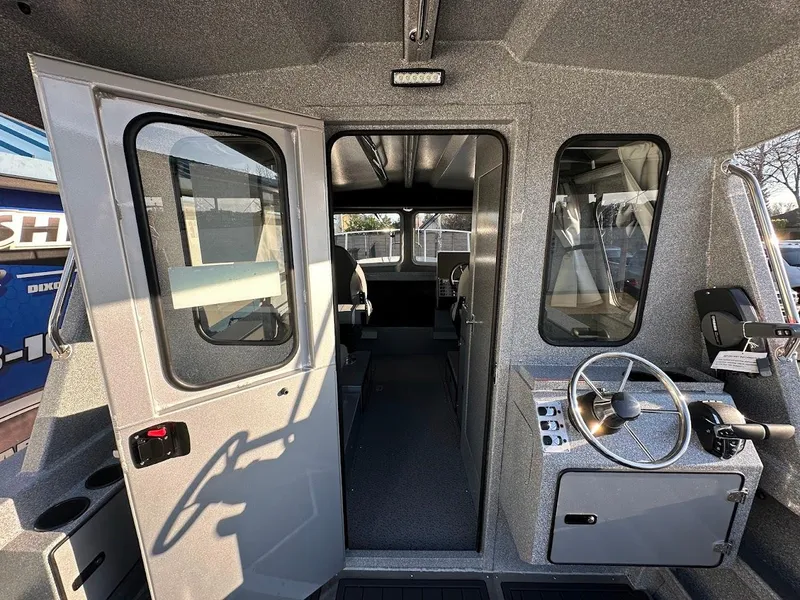 Slide: The Image of Interior view of 2025 KingFisher 2625 Coastal Express boat, featuring helm and cabin entrance. - 30