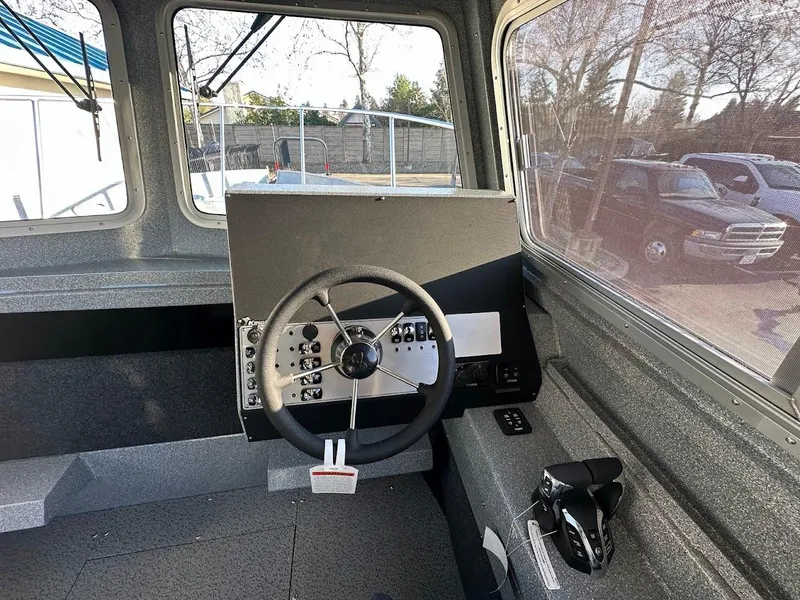 Slide: The Image of Interior of 2025 KingFisher 2625 Coastal Express boat, featuring steering wheel and control panel. - 38