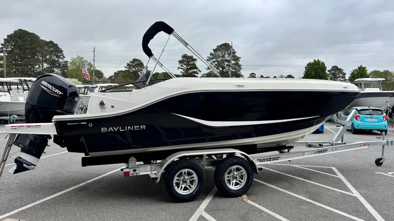 Slide: The Image of 2025 Bayliner D20 boat on trailer, black and white design, parked outdoors. - 2