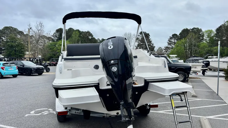 Slide: The Image of 2025 Bayliner D20 boat with outboard motor in a parking lot. - 3