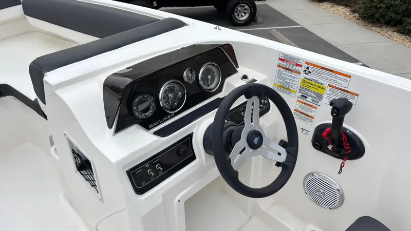 Slide: The Image of 2025 Bayliner D20 boat dashboard with steering wheel and control panel. - 5
