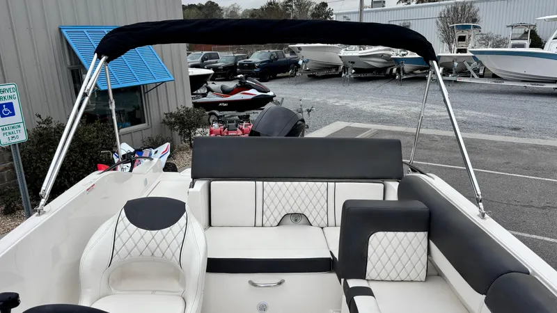 Slide: The Image of 2025 Bayliner D20 boat interior with stylish seating and canopy in a marina setting. - 6