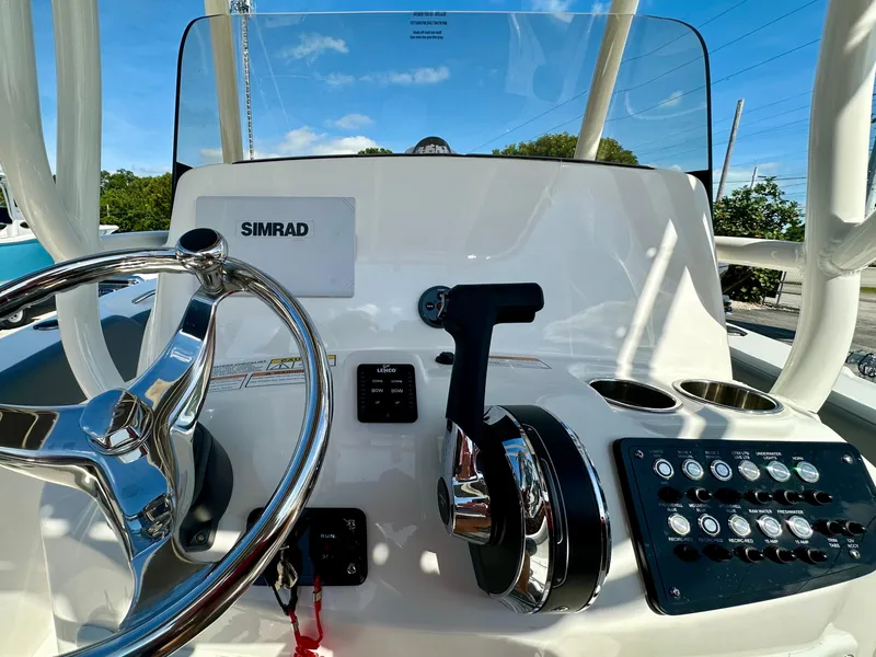 Slide: The Image of 2025 NauticStar 231 Hybrid boat dashboard with steering wheel and controls. - 11