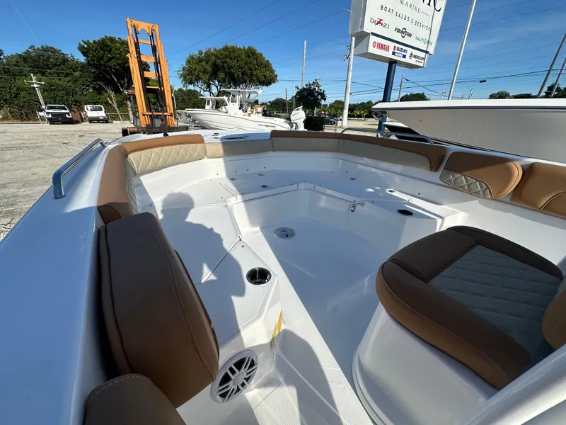 Slide: The Image of 2025 NauticStar 231 Hybrid boat interior with tan seating and cup holders. - 15