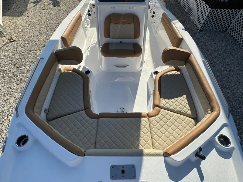 Slide: The Image of 2025 NauticStar 231 Hybrid boat interior with tan cushioned seating and white deck. - 18