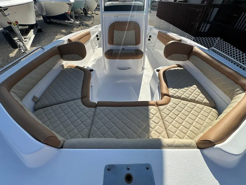 Slide: The Image of 2025 NauticStar 231 Hybrid boat interior with tan and white cushioned seating. - 19
