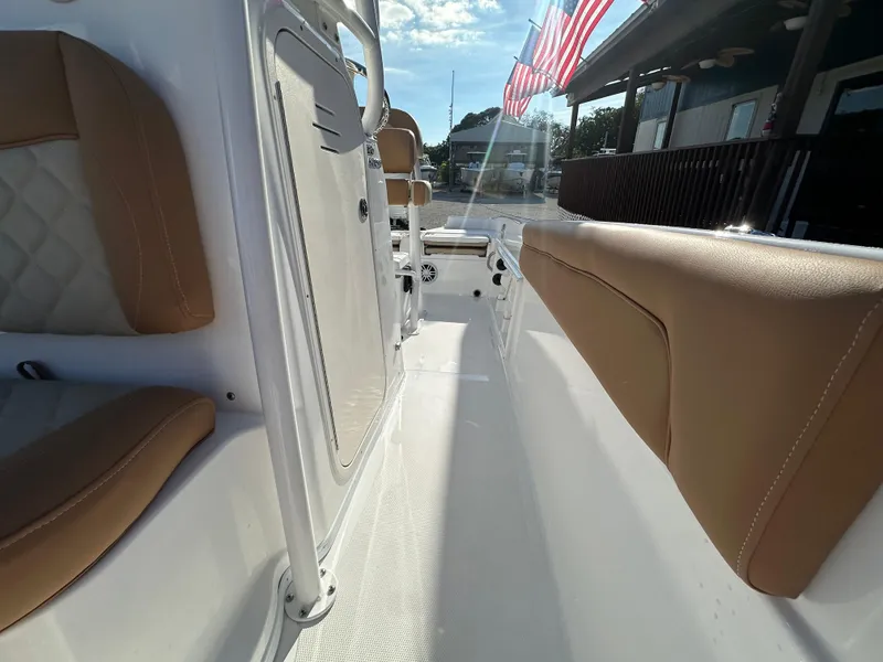 Slide: The Image of 2025 NauticStar 231 Hybrid boat interior with tan seating and American flag. - 20