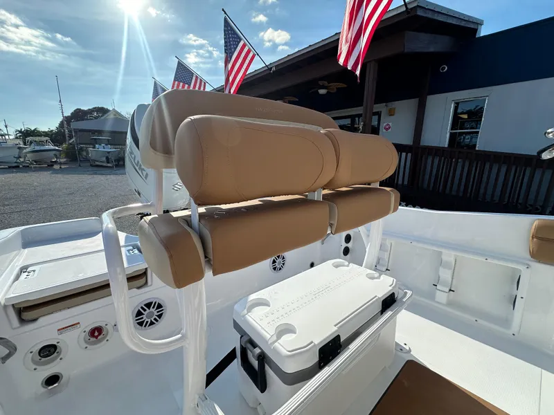 Slide: The Image of 2025 NauticStar 231 Hybrid boat interior with tan seating and American flags. - 21