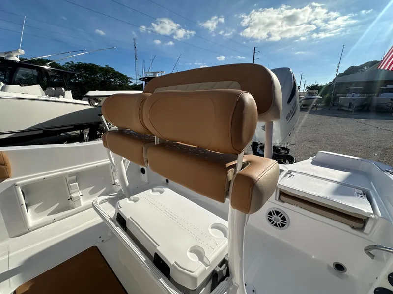 Slide: The Image of 2025 NauticStar 231 Hybrid boat interior with tan seating and storage compartments. - 22