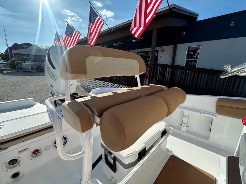 Slide: The Image of 2025 NauticStar 231 Hybrid boat interior with tan seating and American flags. - 24