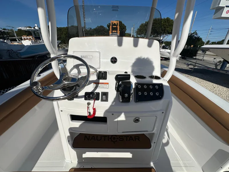 Slide: The Image of 2025 NauticStar 231 Hybrid boat console with steering wheel and controls. - 25