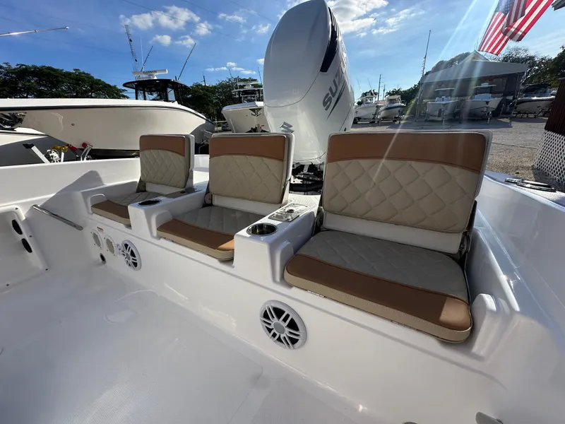Slide: The Image of 2025 NauticStar 231 Hybrid boat seating with beige cushions and cup holders. - 28