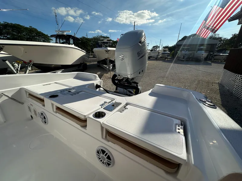 Slide: The Image of 2025 NauticStar 231 Hybrid boat with Suzuki outboard motor, docked under a sunny sky. - 7