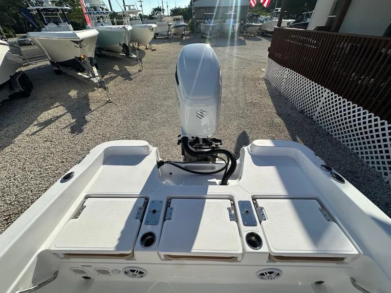 Slide: The Image of 2025 NauticStar 231 Hybrid boat with outboard motor in a marina setting. - 8