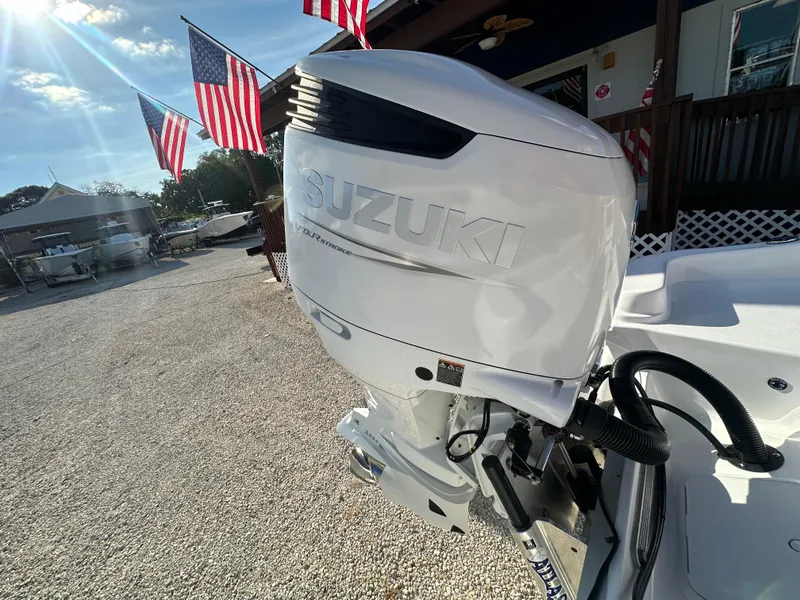 Slide: The Image of 2025 NauticStar 231 Hybrid with Suzuki outboard motor, American flags in background. - 9