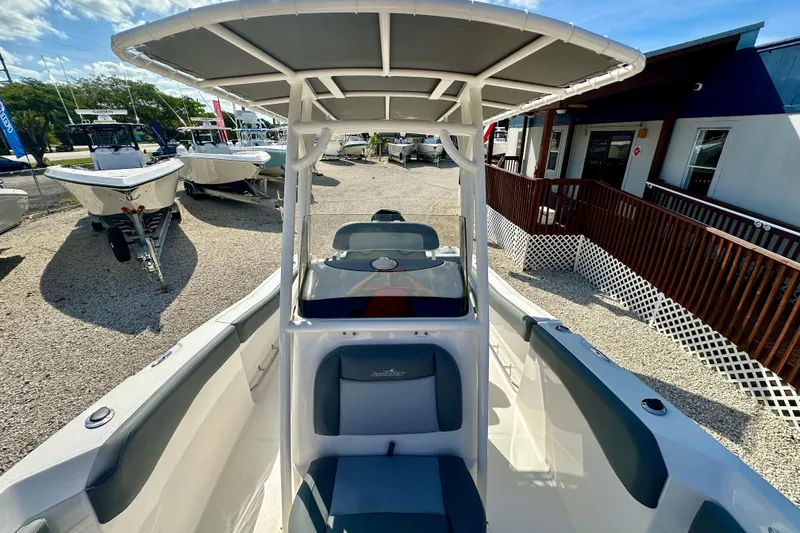 Slide: The Image of 2024 NauticStar 22XS boat with T-top, displayed outdoors at a dealership. - 10