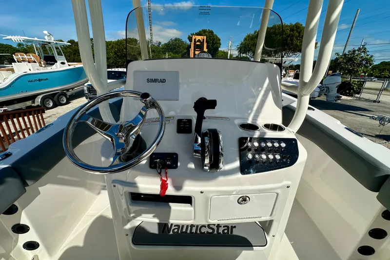 Slide: The Image of 2024 NauticStar 22XS boat console with steering wheel, controls, and Simrad display. - 13